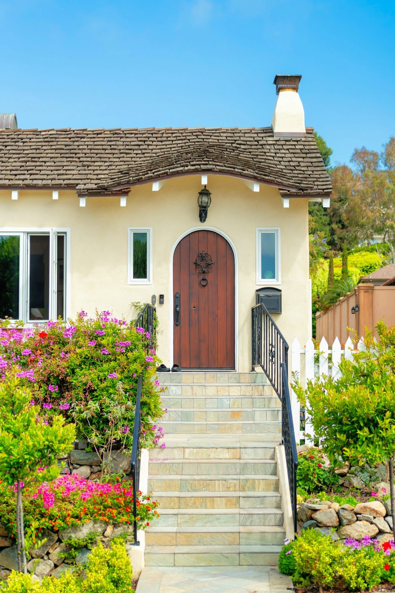 Vertical shot of the exterior of a house with concrete stairs and metal handrails